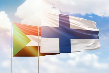 Sunny blue sky and flags of finland and sudan