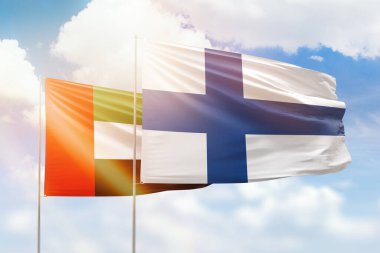 Sunny blue sky and flags of finland and uae