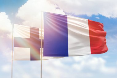 Sunny blue sky and flags of france and finland