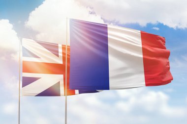 Sunny blue sky and flags of france and great britain