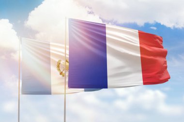 Sunny blue sky and flags of france and guatemala