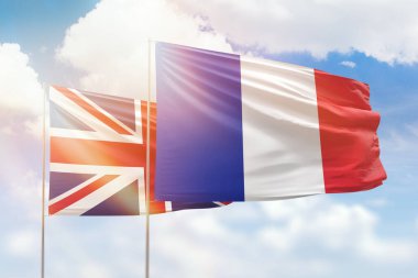 Sunny blue sky and flags of france and united kingdom