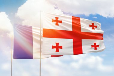 Sunny blue sky and flags of georgia and france