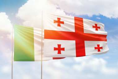 Sunny blue sky and flags of georgia and italy