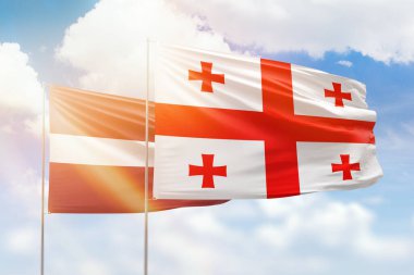 Sunny blue sky and flags of georgia and latvia