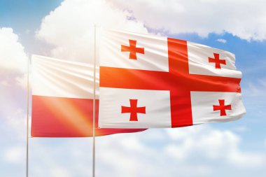 Sunny blue sky and flags of georgia and poland