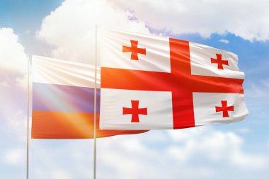 Sunny blue sky and flags of georgia and russia