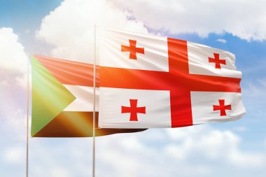 Sunny blue sky and flags of georgia and sudan