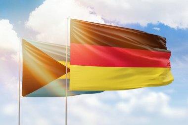 Sunny blue sky and flags of germany and bahamas