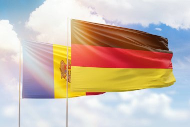 Sunny blue sky and flags of germany and moldova