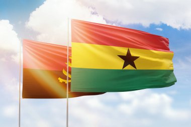 Sunny blue sky and flags of ghana and angola