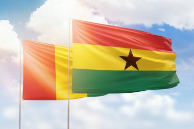 Sunny blue sky and flags of ghana and guinea
