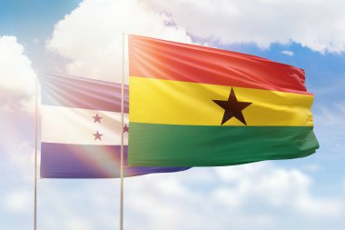 Sunny blue sky and flags of ghana and honduras