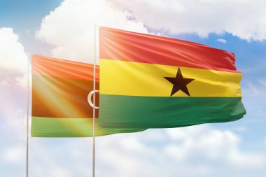 Sunny blue sky and flags of ghana and libya
