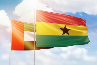 Sunny blue sky and flags of ghana and uae