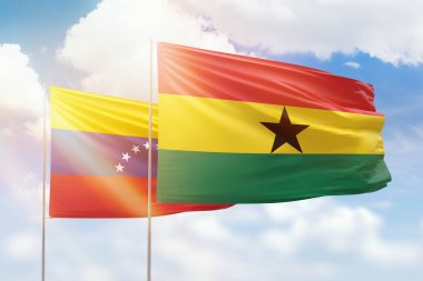 Sunny blue sky and flags of ghana and venezuela