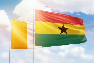 Sunny blue sky and flags of ghana and ivory coast