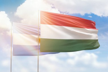 Sunny blue sky and flags of hungary and argentina