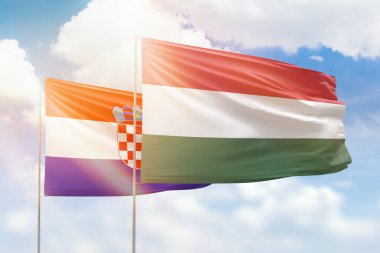 Sunny blue sky and flags of hungary and croatia