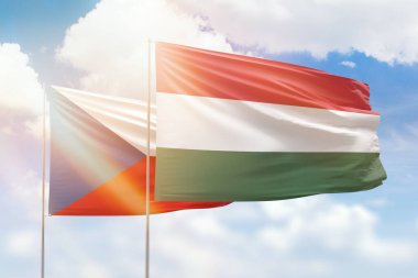 Sunny blue sky and flags of hungary and czechia