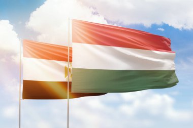Sunny blue sky and flags of hungary and egypt