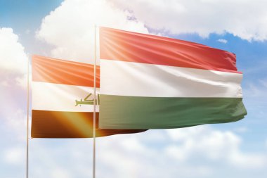 Sunny blue sky and flags of hungary and iraq