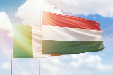 Sunny blue sky and flags of hungary and ireland