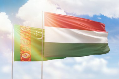 Sunny blue sky and flags of hungary and turkmenistan