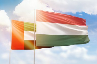 Sunny blue sky and flags of hungary and uae
