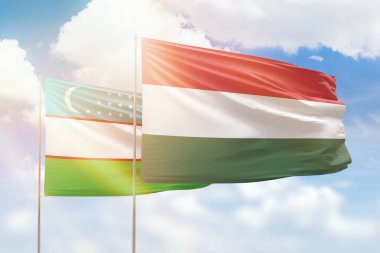 Sunny blue sky and flags of hungary and uzbekistan