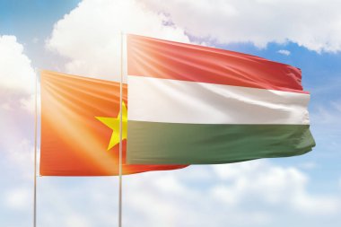 Sunny blue sky and flags of hungary and vietnam