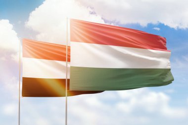 Sunny blue sky and flags of hungary and yemen