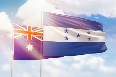 Sunny blue sky and flags of honduras and australia