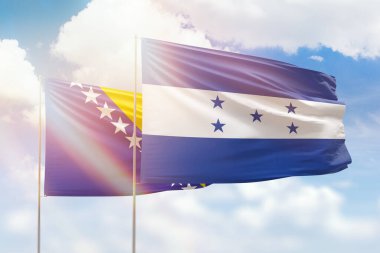 Sunny blue sky and flags of honduras and bosnia