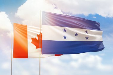 Sunny blue sky and flags of honduras and canada