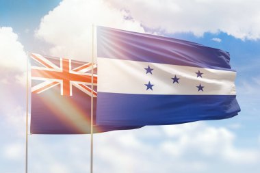 Sunny blue sky and flags of honduras and new zealand