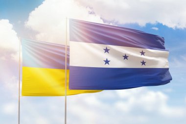 Sunny blue sky and flags of honduras and ukraine