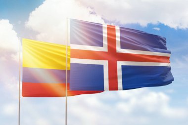Sunny blue sky and flags of iceland and colombia