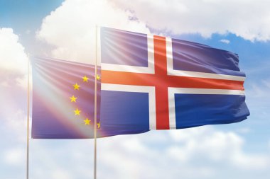Sunny blue sky and flags of iceland and european union