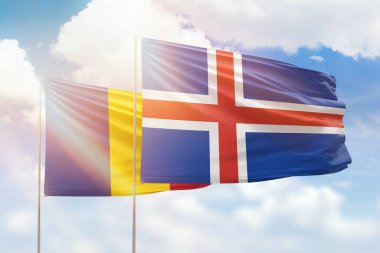 Sunny blue sky and flags of iceland and romania