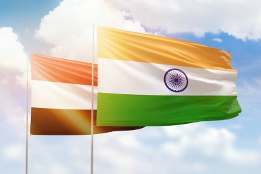 Sunny blue sky and flags of india and yemen