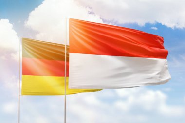 Sunny blue sky and flags of indonesia and germany