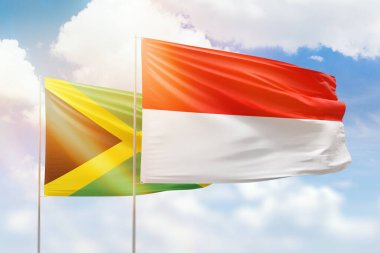 Sunny blue sky and flags of indonesia and jamaica