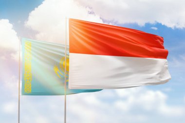 Sunny blue sky and flags of indonesia and kazakhstan