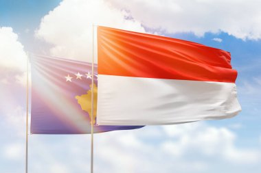 Sunny blue sky and flags of indonesia and kosovo