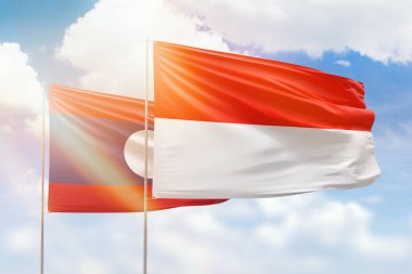 Sunny blue sky and flags of indonesia and laos