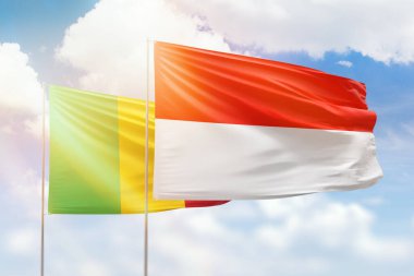 Sunny blue sky and flags of indonesia and mali