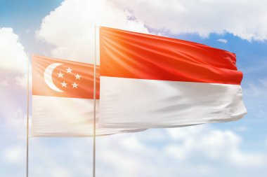 Sunny blue sky and flags of indonesia and singapore