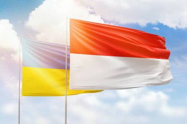 Sunny blue sky and flags of indonesia and ukraine