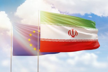 Sunny blue sky and flags of iran and european union